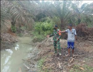 Cegah Banjir Babinsa Serka Sutiyono Pantau Saluran Air